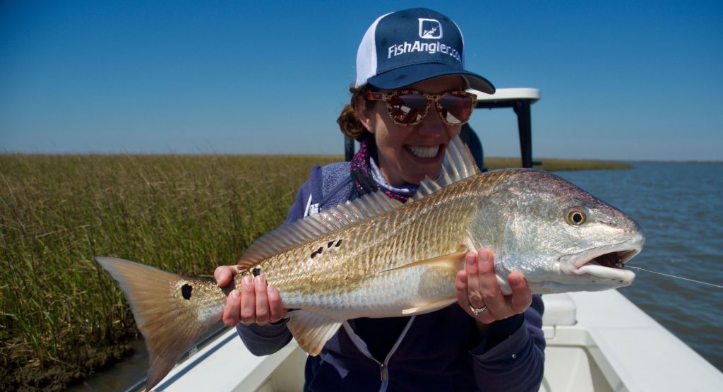 Woman holding a red drum fish
