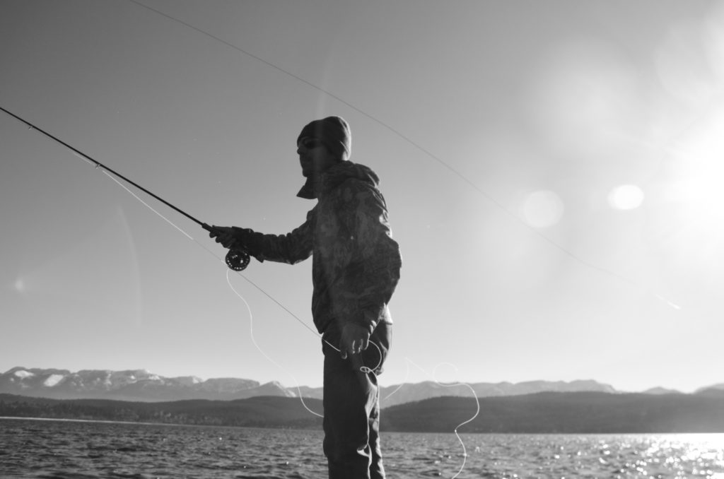 Black and white picture of a man fly fishing