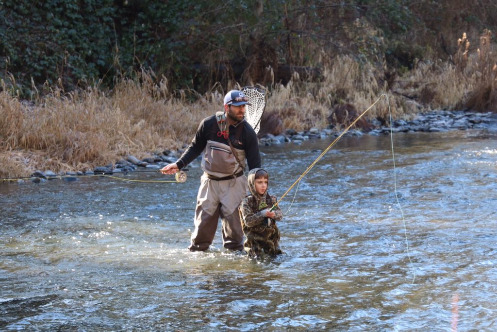 Dad fishing with son in river