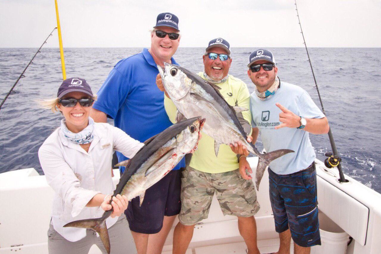 Picture of four people on a boat holding fish