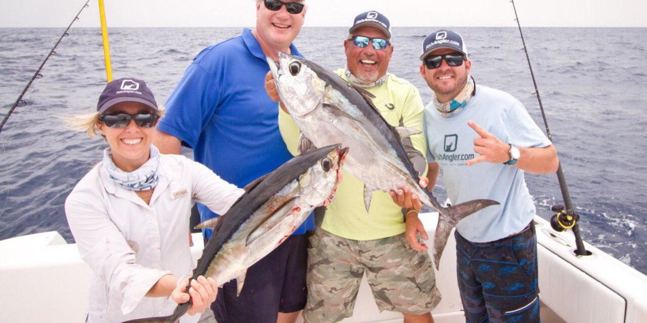 Picture of four people on a boat holding fish