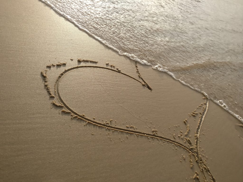 Image of a heart in sand on the beach